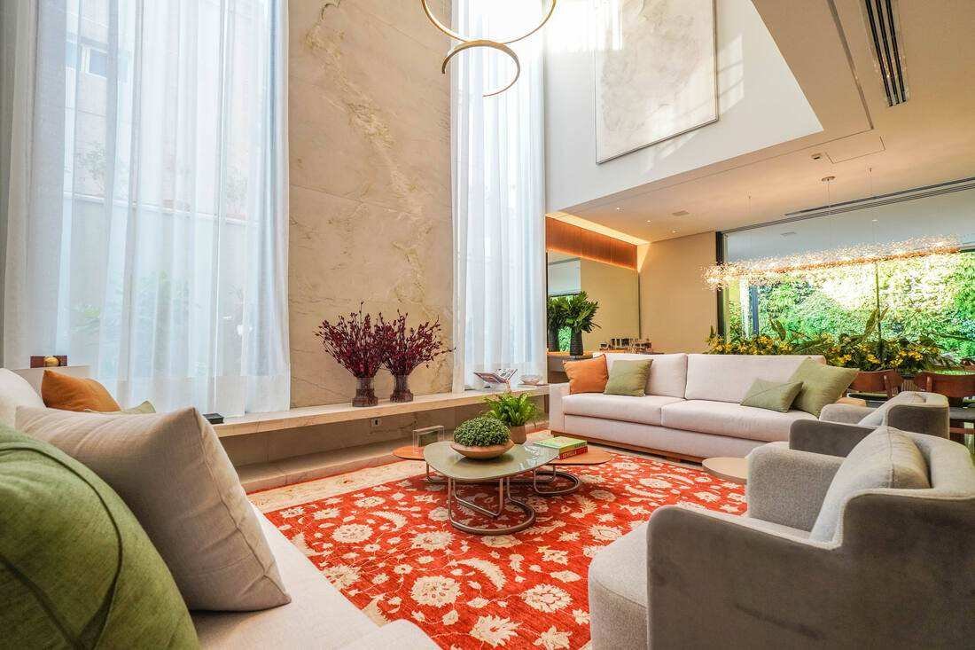 Sala de estar com pé-direito duplo e parede de mármore